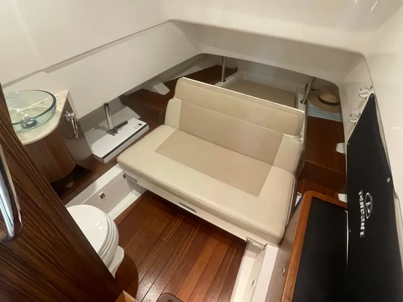 Slide: The Image of 2019 Pursuit S 328 Sport cabin interior with seating, sink, and wooden flooring. - 49