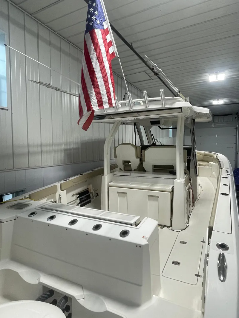 Slide: The Image of 2019 Pursuit S 328 Sport boat in a garage with an American flag. - 5