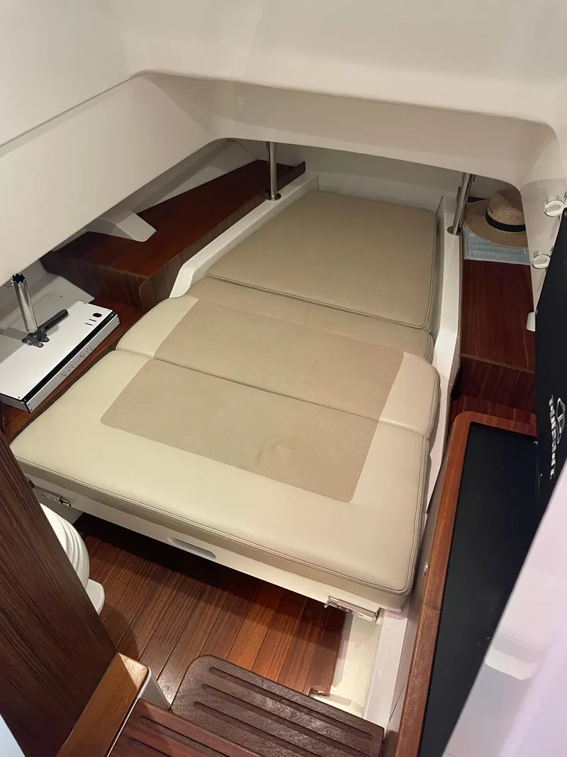 Slide: The Image of 2019 Pursuit S 328 Sport cabin interior with beige cushions and wooden flooring. - 50