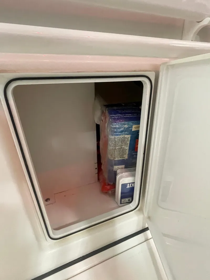 Slide: The Image of Storage compartment on a 2019 Pursuit S 328 Sport boat, containing packaged items. - 55