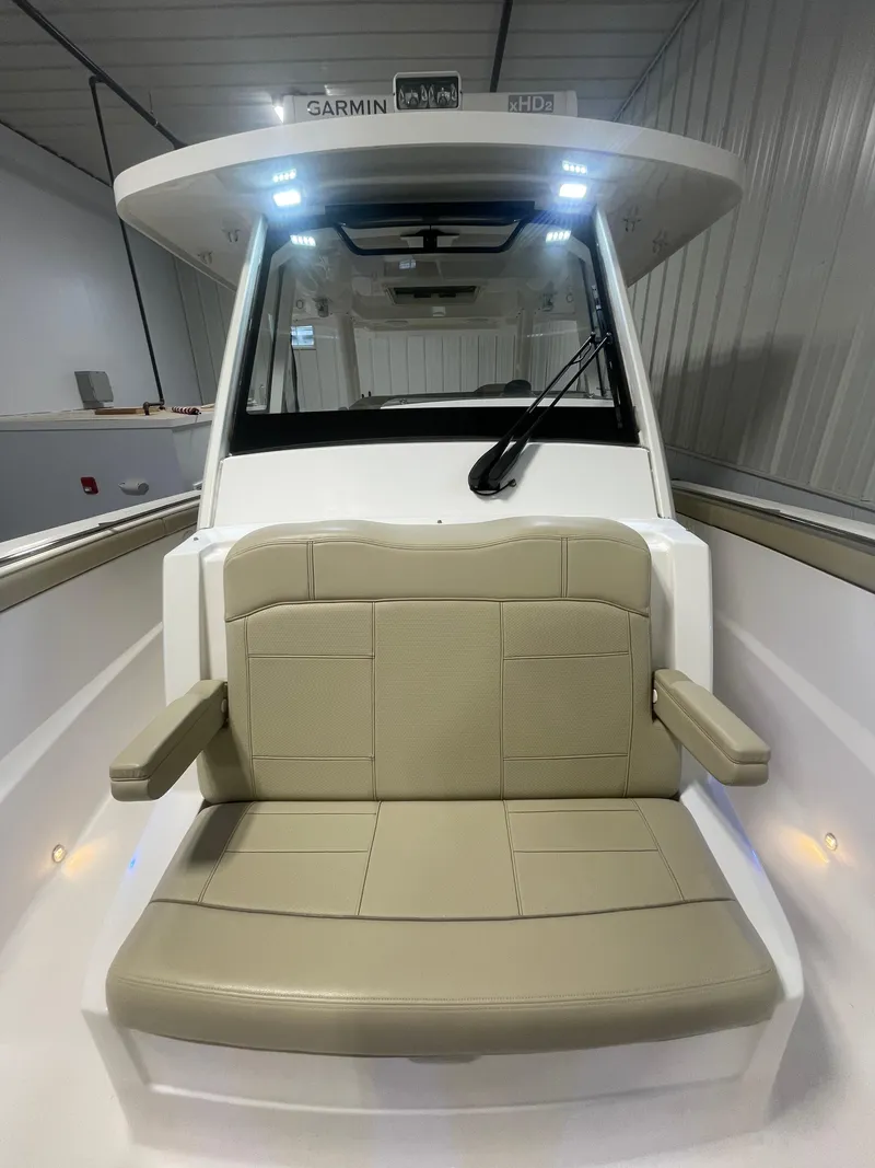 Slide: The Image of 2019 Pursuit S 328 Sport boat interior with beige seating and modern dashboard. - 8