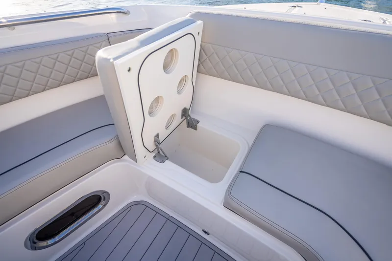 Slide: The Image of 2022 Pursuit DC 365 Dual Console boat interior with storage compartment and quilted seating. - 31