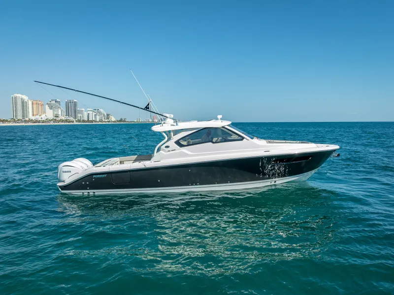 Slide: The Image of 2022 Pursuit DC 365 Dual Console boat cruising on blue ocean near city skyline. - 9