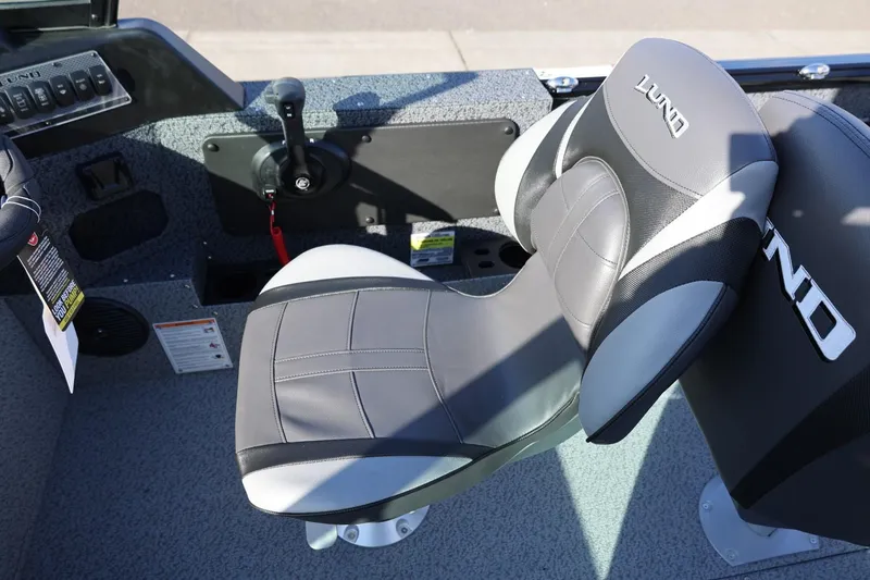 Slide: The Image of 2025 Lund 1875 Impact XS Sport boat interior with sleek, modern seating and controls. - 12