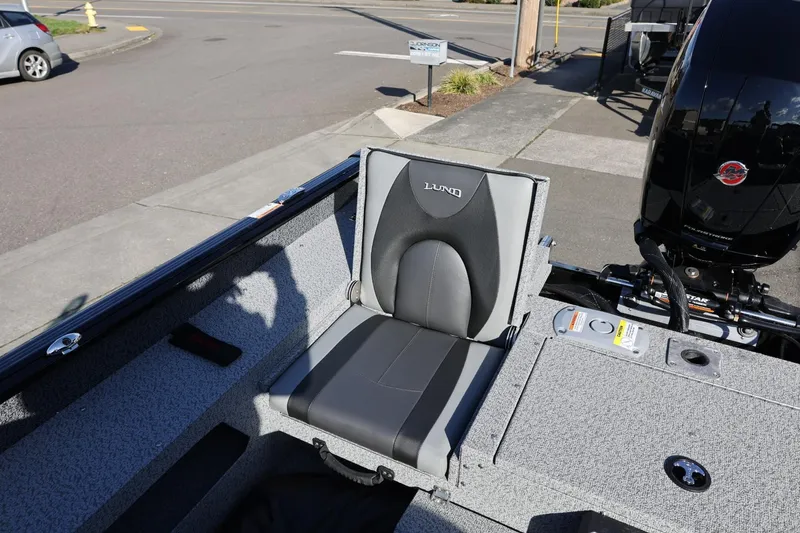 Slide: The Image of 2025 Lund 1875 Impact XS Sport boat seat, gray and black design, outdoor setting. - 16