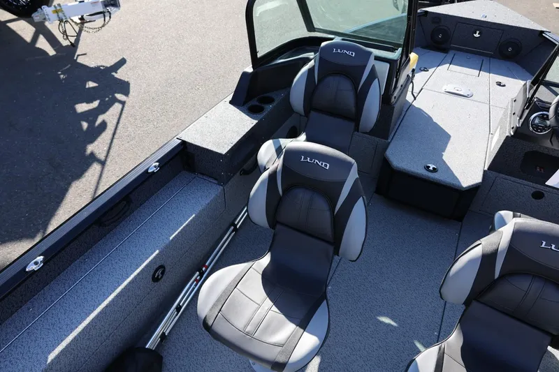 Slide: The Image of 2025 Lund 1875 Impact XS Sport boat interior with cushioned seats and storage compartments. - 19