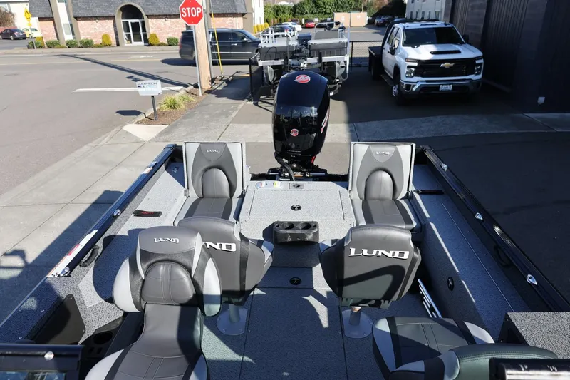 Slide: The Image of 2025 Lund 1875 Impact XS Sport boat interior with seating, parked on a street. - 38
