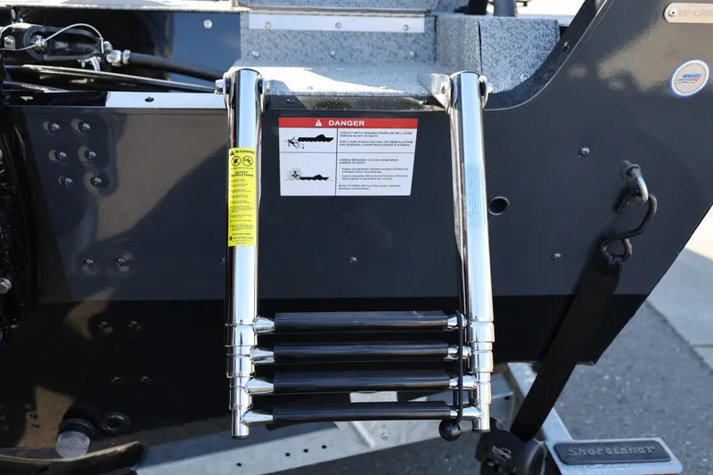 Slide: The Image of 2025 Lund 1875 Impact XS Sport boat ladder with safety warning label. - 39