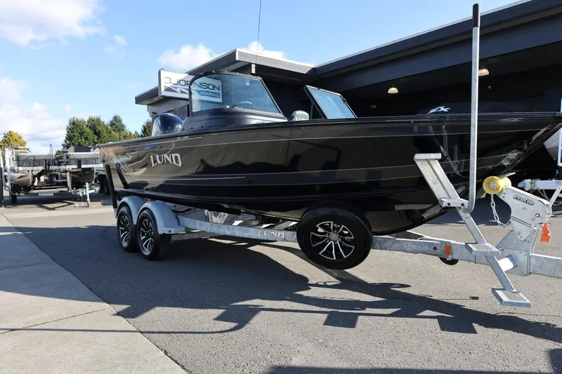 Slide: The Image of 2025 Lund 1875 Impact XS Sport boat on trailer, parked outdoors. - 5