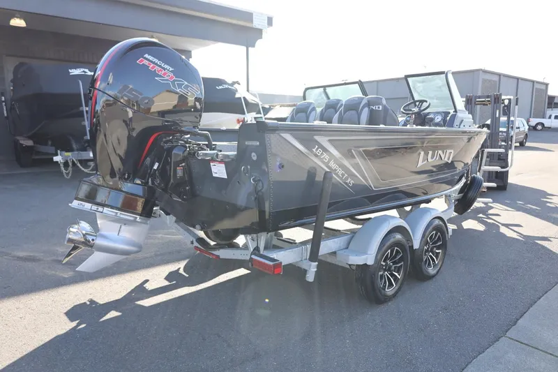 Slide: The Image of 2025 Lund 1875 Impact XS Sport boat on trailer, parked outdoors. - 6
