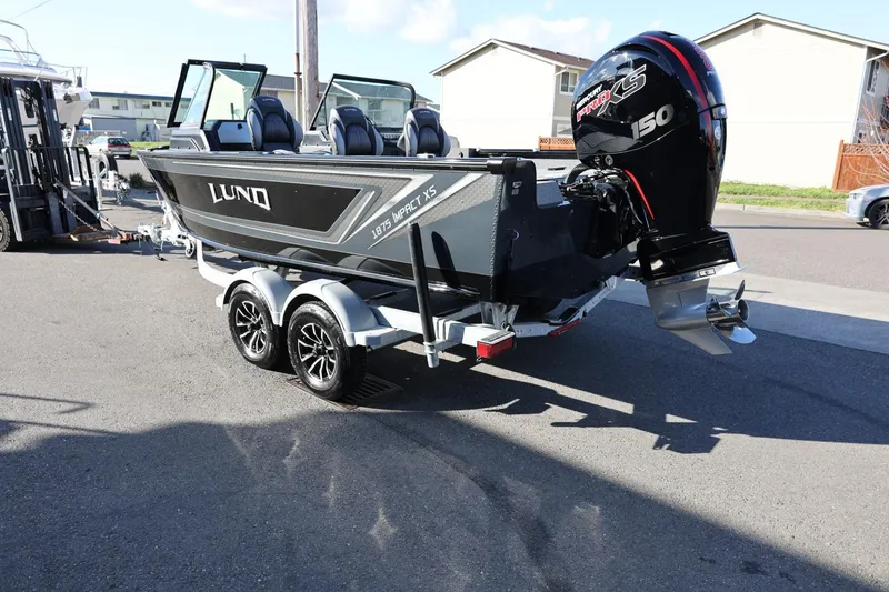 Slide: The Image of 2025 Lund 1875 Impact XS Sport boat on trailer, parked outdoors. - 8
