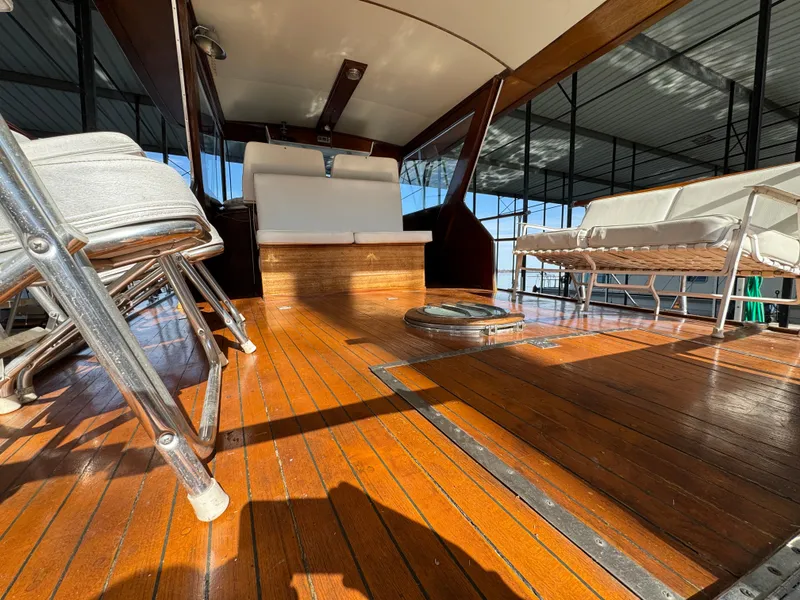 Slide: The Image of 1964 Chris-Craft Roamer 46 yacht interior with polished wooden deck and seating. - 12