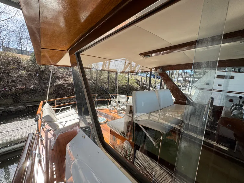 Slide: The Image of 1964 Chris-Craft Roamer 46 yacht with wooden deck and seating area, docked at marina. - 14