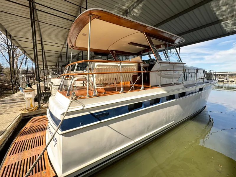 The Image of 1964 Chris-Craft Roamer 46 yacht docked under a covered marina. - 0