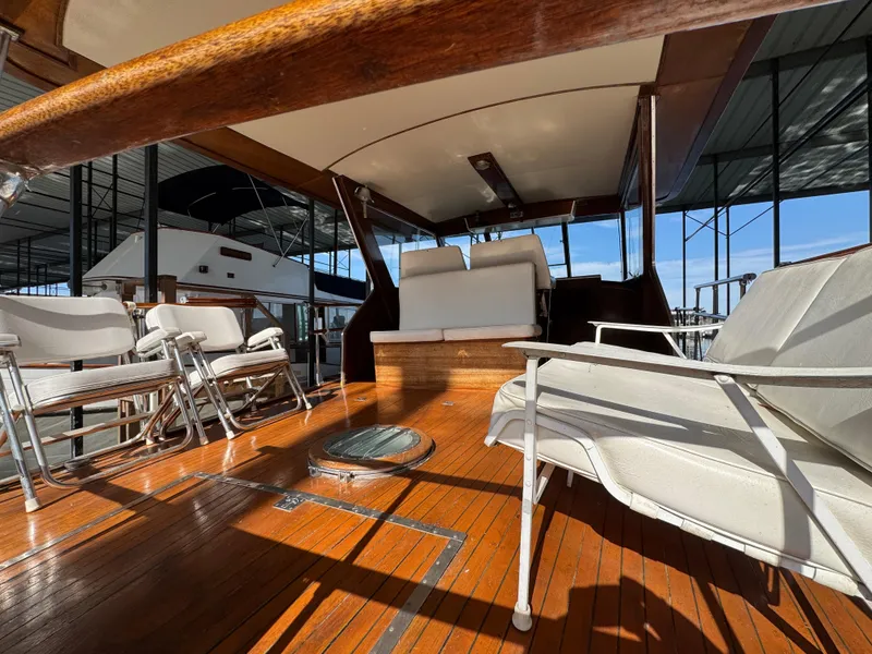 Slide: The Image of 1964 Chris-Craft Roamer 46 yacht interior with wooden deck and white seating. - 13