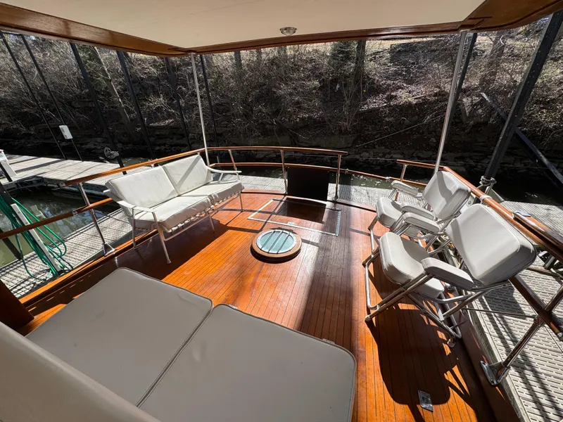 Slide: The Image of 1964 Chris-Craft Roamer 46 yacht deck with white seating and wooden flooring. - 15