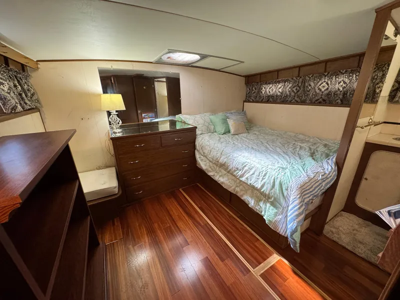 Slide: The Image of 1964 Chris-Craft Roamer 46 cabin interior with bed, wooden flooring, and dresser. - 25