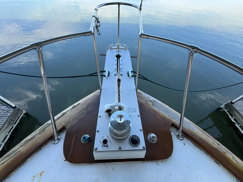 Slide: The Image of 1964 Chris-Craft Roamer 46 yacht bow with anchor winch, surrounded by calm water. - 5