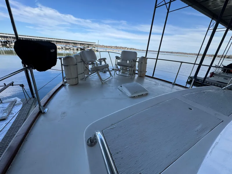 Slide: The Image of 1964 Chris-Craft Roamer 46 yacht deck with chairs, docked by calm waters. - 7