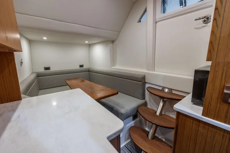 Slide: The Image of Luxurious interior of 2023 Front Runner 47 yacht with sleek wooden table and cushioned seating. - 24