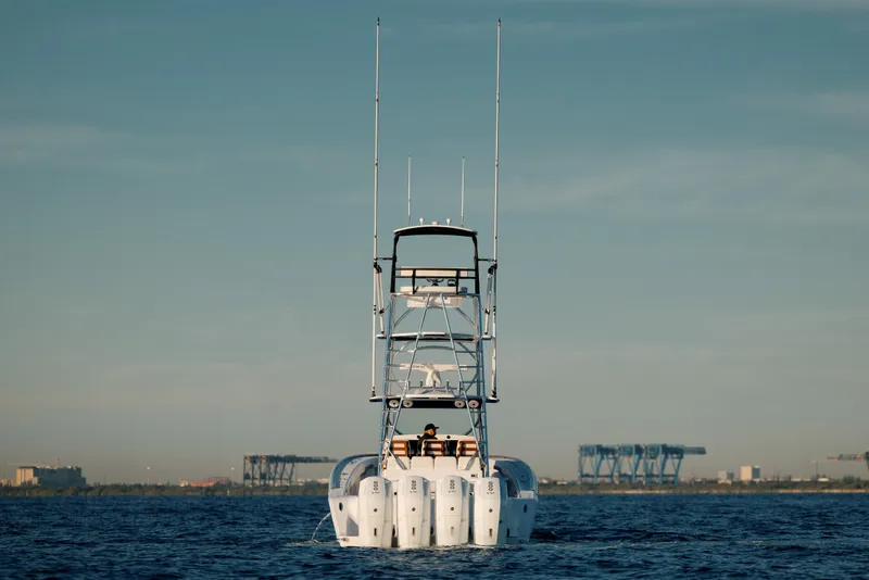 Slide: The Image of 2023 Front Runner 47 boat on calm water with distant industrial background. - 4