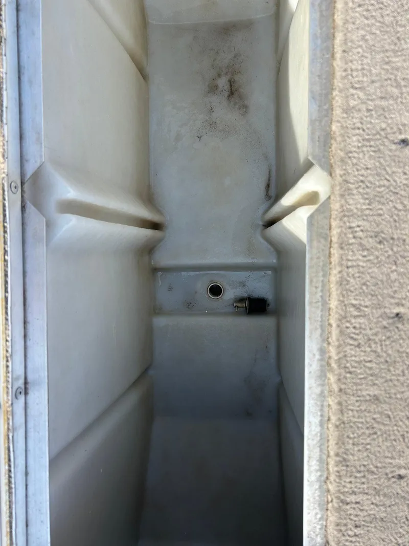 Slide: The Image of 2002 Lund Pro Angler 16 boat compartment interior, showing storage space and drain hole. - 15