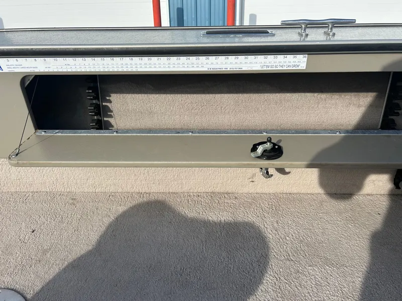 Slide: The Image of 2002 Lund Pro Angler 16 boat interior with storage compartment and measuring ruler. - 16