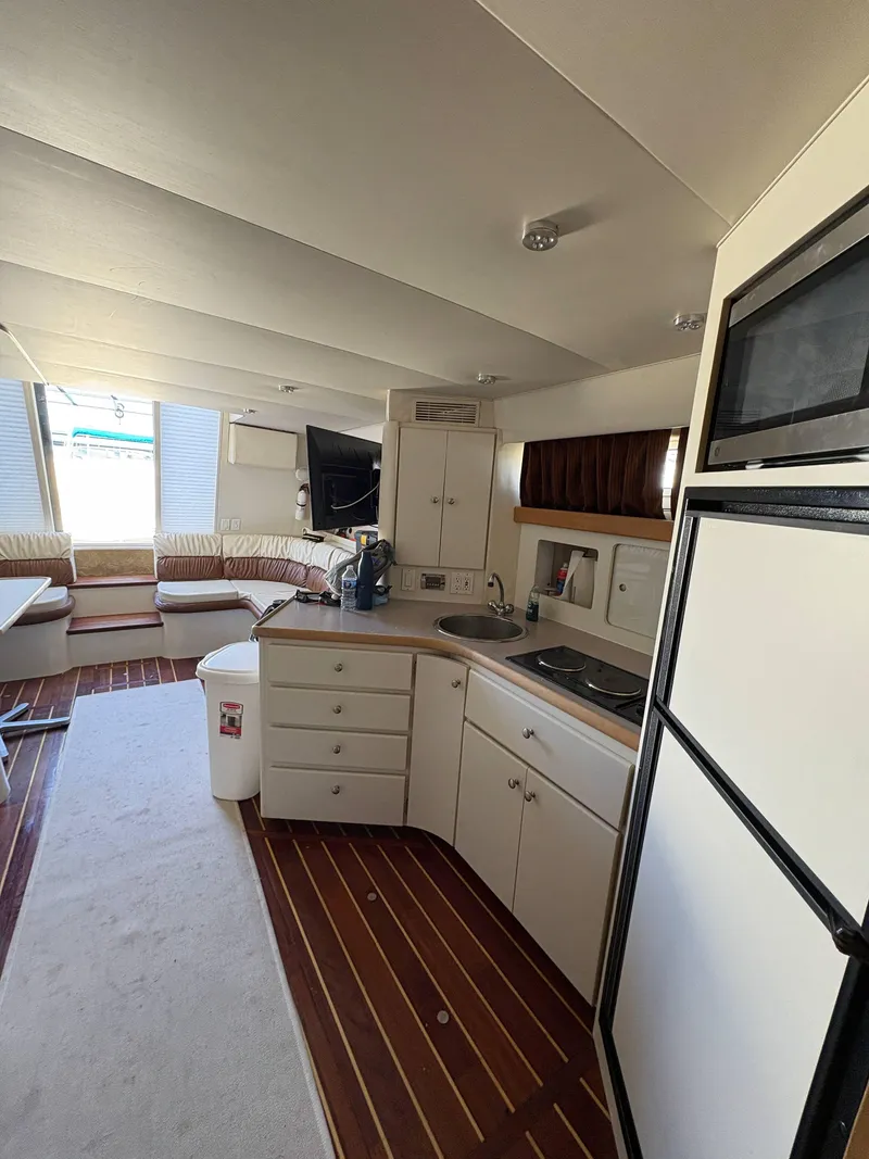 Slide: The Image of Interior of 1994 Carver 380 Santego yacht with kitchen and seating area. - 10