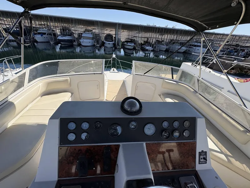 Slide: The Image of 1994 Carver 380 Santego yacht cockpit with dashboard and seating, docked at marina. - 7