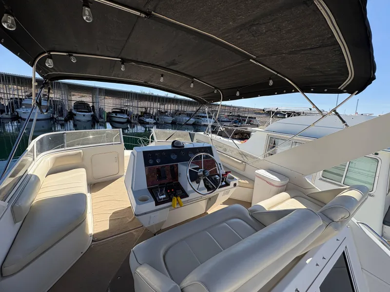 Slide: The Image of 1994 Carver 380 Santego yacht interior with helm, seating, and canopy in marina setting. - 8