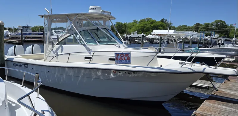 The Image of 1999 Pursuit 2870 Walkaround boat for sale at a marina dock. - 0