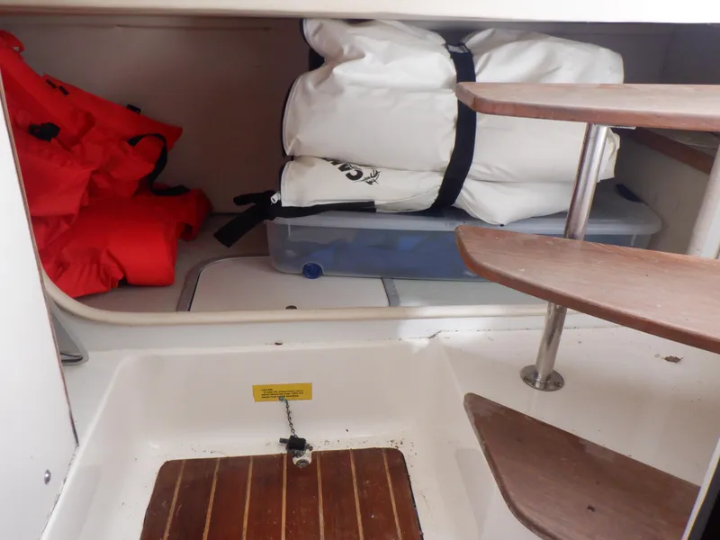 Slide: The Image of Interior of 1999 Pursuit 2870 Walkaround boat with life jackets and storage. - 10