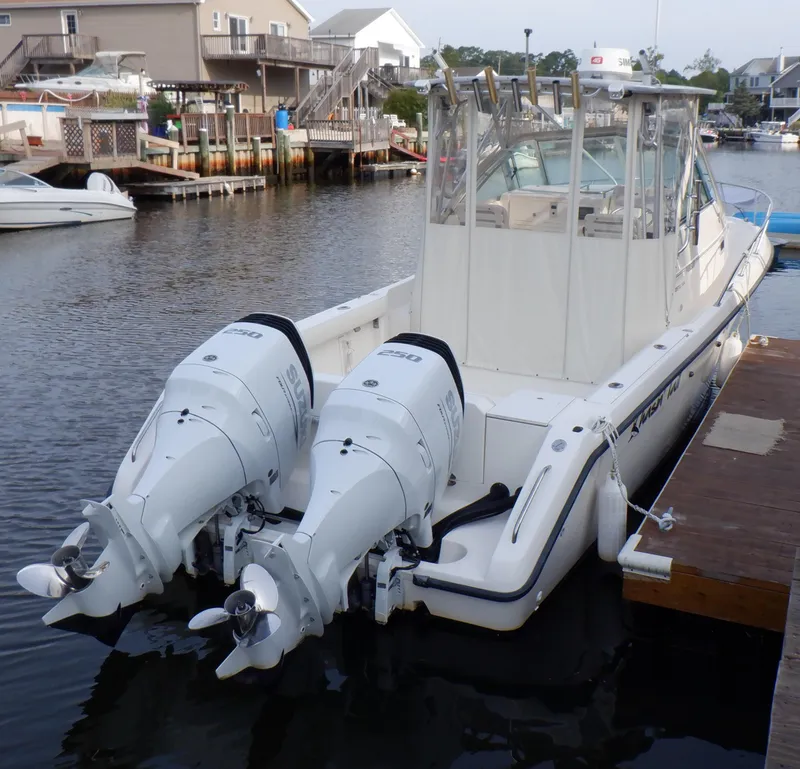 Slide: The Image of 1999 Pursuit 2870 Walkaround boat docked with dual outboard engines. - 16