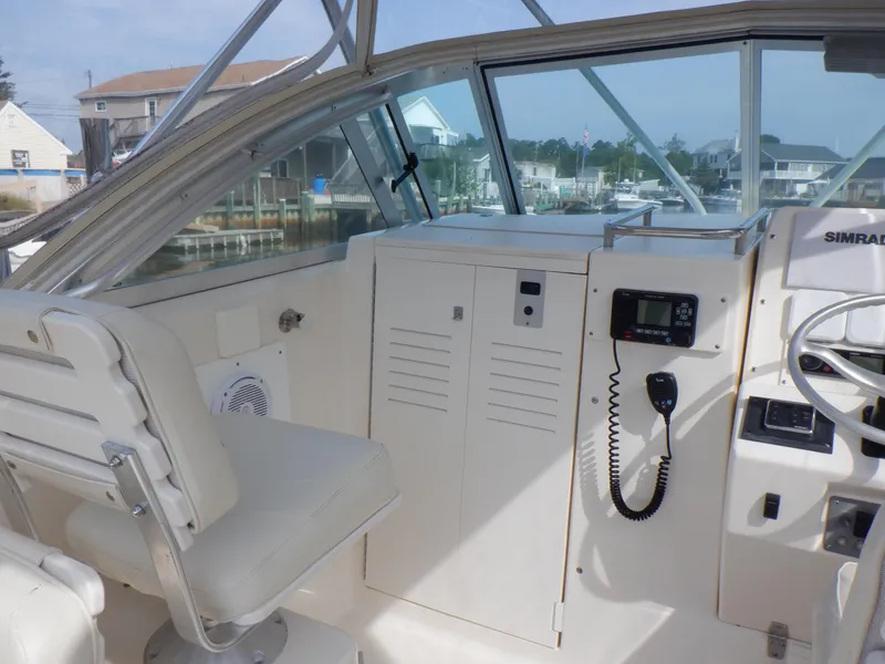 Slide: The Image of 1999 Pursuit 2870 Walkaround boat interior with helm, seating, and navigation equipment. - 17