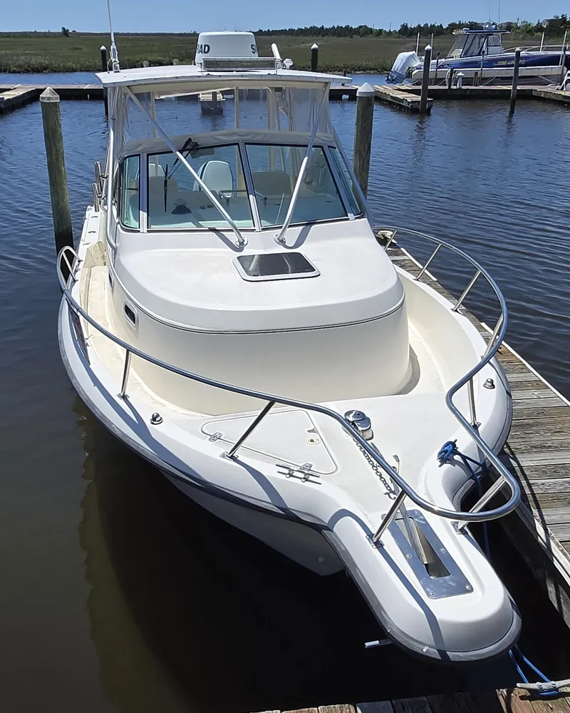 Slide: The Image of 1999 Pursuit 2870 Walkaround boat docked in a marina, front view. - 18