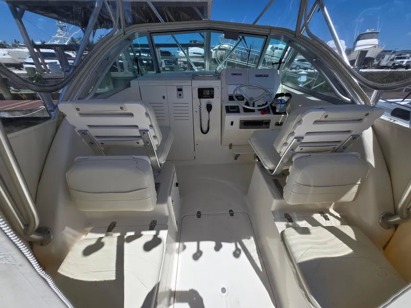 Slide: The Image of 1999 Pursuit 2870 Walkaround boat interior with helm and seating. - 2