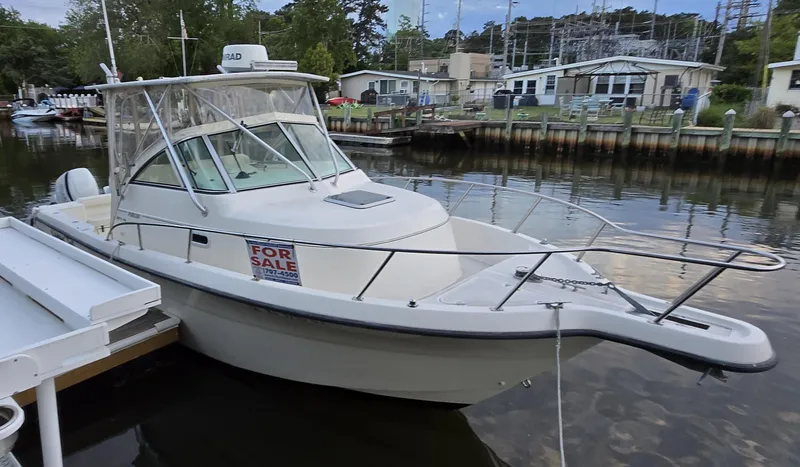 Slide: The Image of 1999 Pursuit 2870 Walkaround boat docked, with "For Sale" sign displayed. - 20