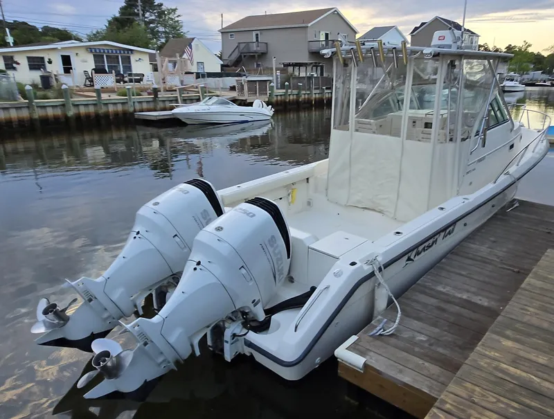 Slide: The Image of 1999 Pursuit 2870 Walkaround boat docked with twin outboard engines in a serene marina setting. - 21