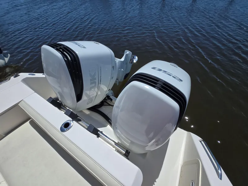 Slide: The Image of 1999 Pursuit 2870 Walkaround boat with dual outboard engines on water. - 23
