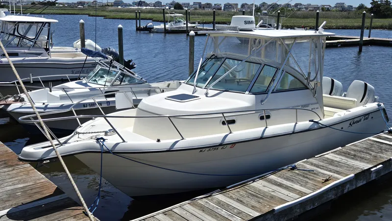 Slide: The Image of 1999 Pursuit 2870 Walkaround boat docked at a marina, ready for a fishing adventure. - 3