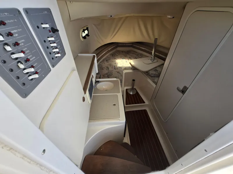 Slide: The Image of 1999 Pursuit 2870 Walkaround cabin interior with control panel and compact amenities. - 4