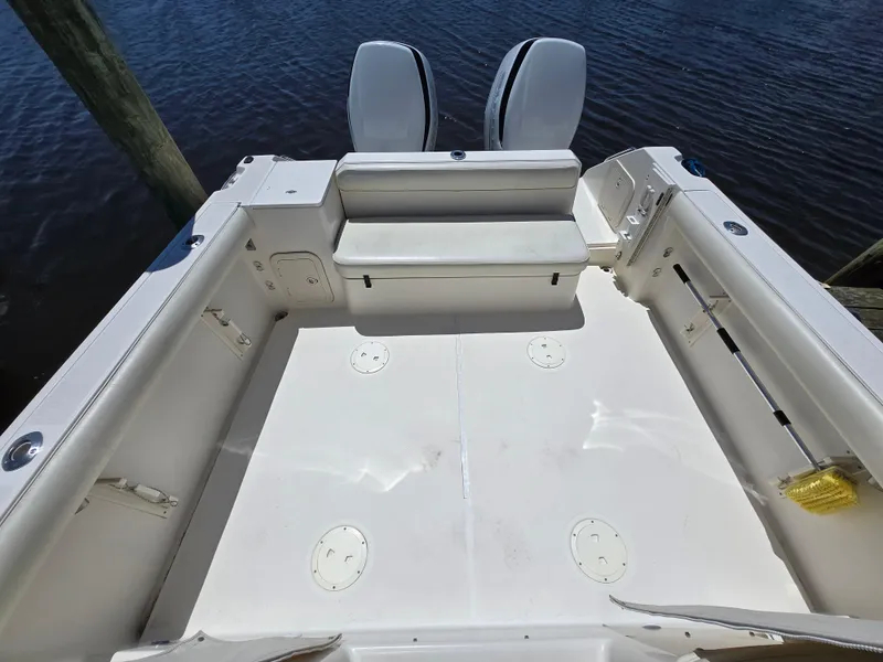 Slide: The Image of 1999 Pursuit 2870 Walkaround boat deck with twin engines, spacious seating, and clean design. - 5