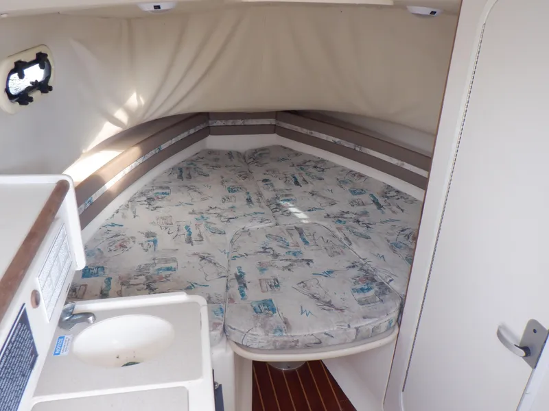 Slide: The Image of 1999 Pursuit 2870 Walkaround cabin interior with bed and sink. - 6