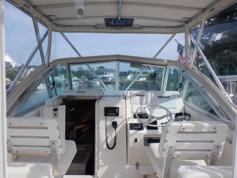 Slide: The Image of 1999 Pursuit 2870 Walkaround boat interior with steering wheel and seating. - 7