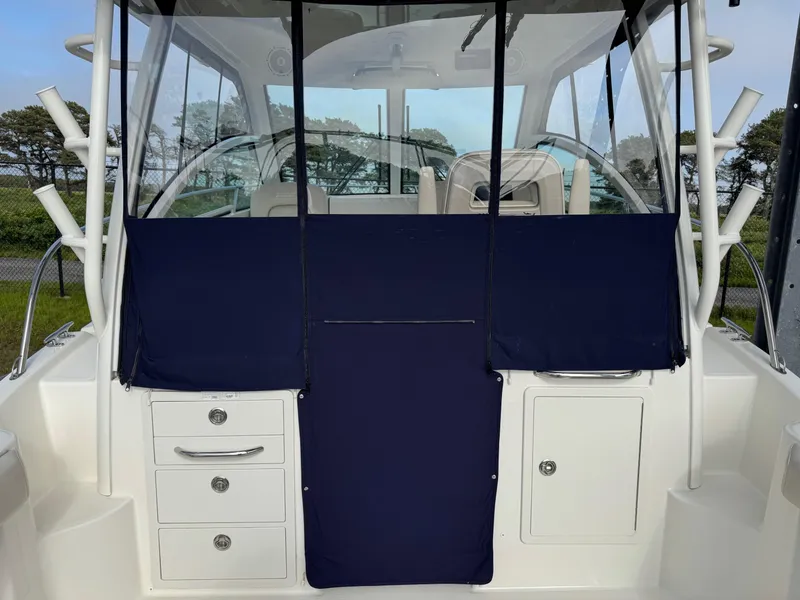 Slide: The Image of 2022 Boston Whaler 285 Conquest boat interior with navy covers and storage compartments. - 21