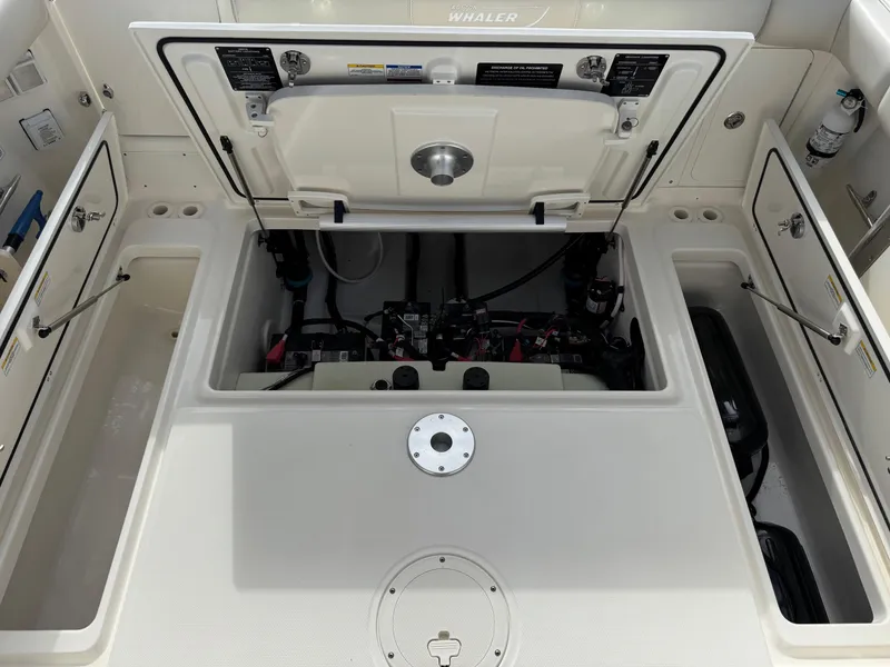 Slide: The Image of 2022 Boston Whaler 285 Conquest engine compartment, showcasing internal components and storage. - 23