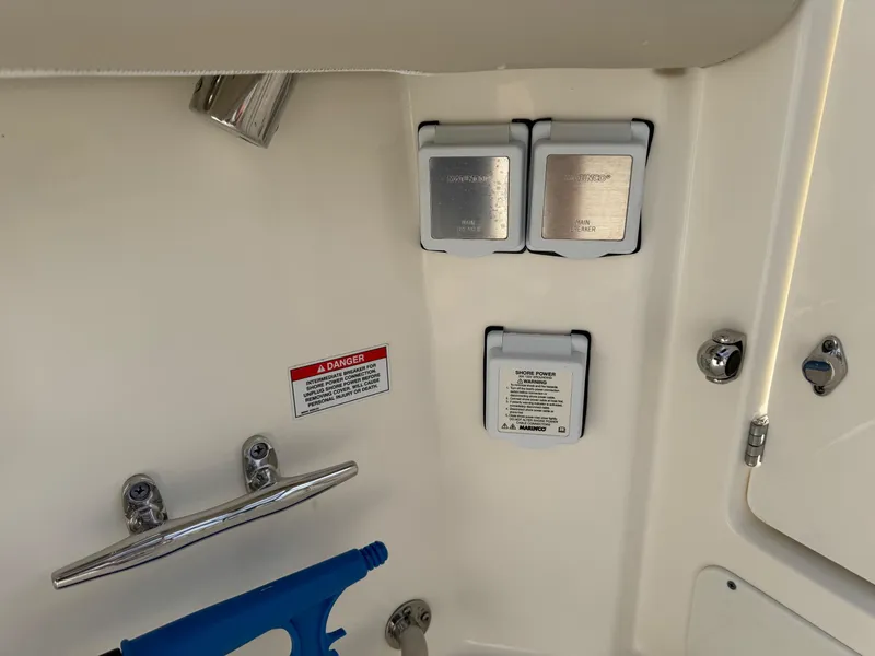 Slide: The Image of 2022 Boston Whaler 285 Conquest boat electrical panel with shore power connections. - 27
