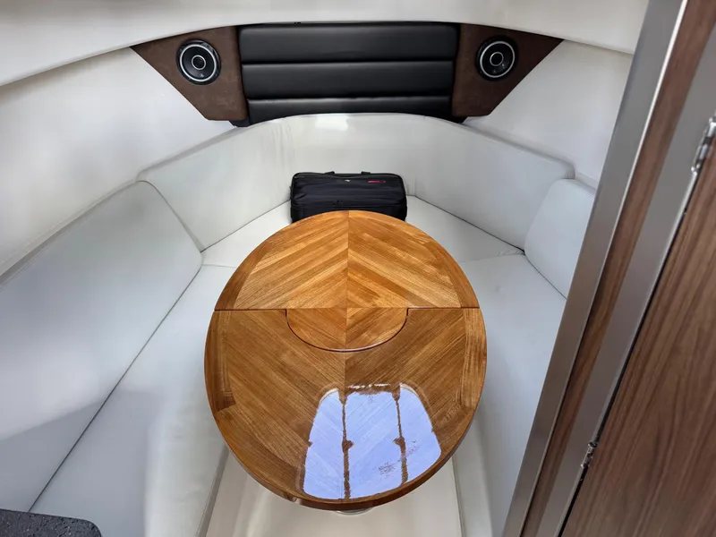 Slide: The Image of Interior of 2022 Boston Whaler 285 Conquest with wooden table and white seating. - 9