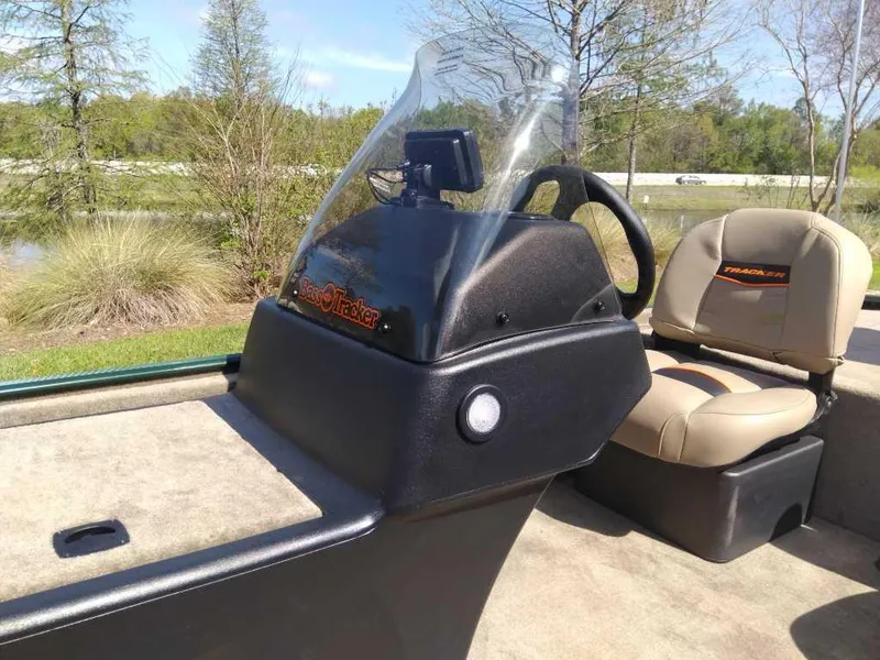 Slide: The Image of 2025 Tracker Bass Tracker Classic Limited boat console and seating in outdoor setting. - 9