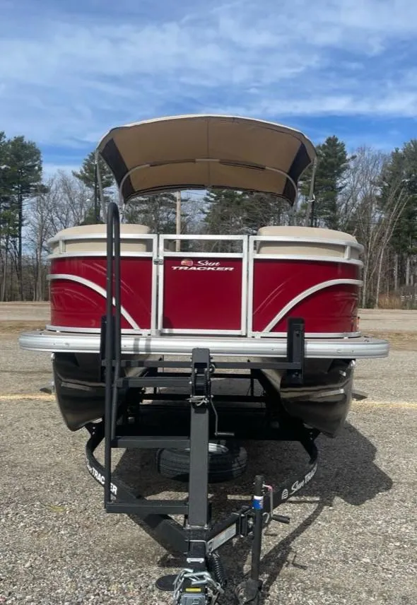 Slide: The Image of 2025 Sun Tracker Party Barge 20 DLX pontoon boat on trailer, parked outdoors. - 5